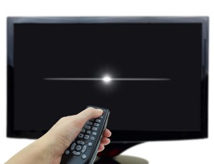 Black tv display with hand and remote control