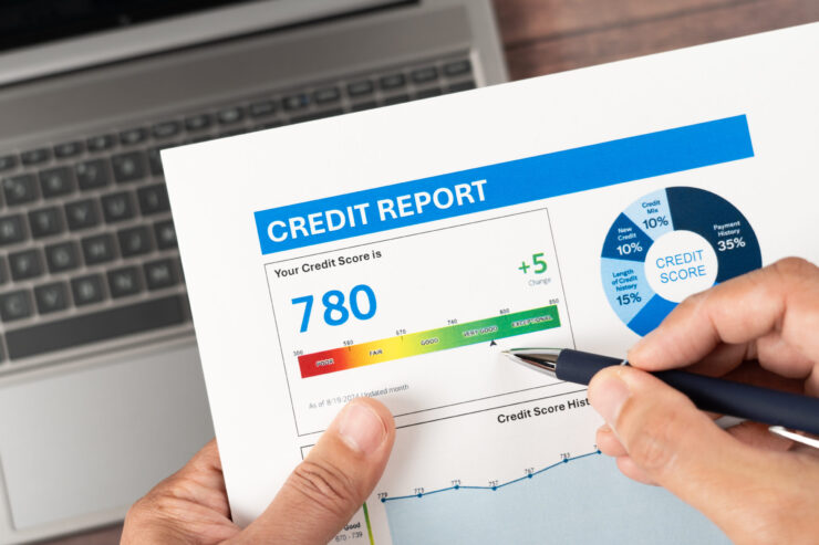 A person reviews a credit report showing a score of 780 in blue, categorized as 
