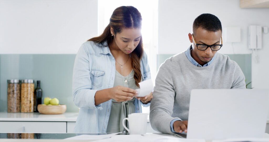 Kitchen, reading and couple with laptop, morning and woman with receipt, bills and planning for pay.