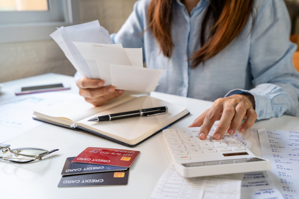 Stressed young woman calculating monthly home expenses, taxes, bank account balance and credit card bills payment, Income is not enough for expenses