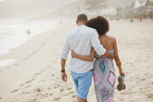 Couple walking on the beach, holding each other closely, enjoying a free Valentines day