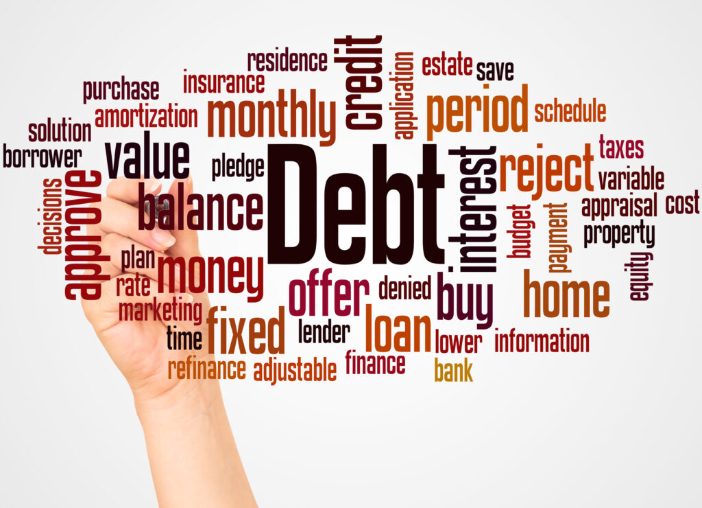 A hand writes on a word cloud centered around the word "Debt," surrounded by terms like "credit," "loan," "interest," and "balance," conveying financial themes.